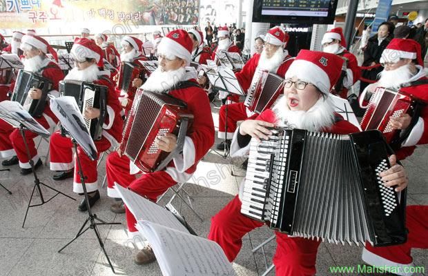 عکس بابانوئل های موزیسین در حال اجرای برنامه در ایستگاه قطار سئول